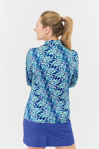 The Pure Golf Serenity long-sleeve ladies zip top from the back features a calming aquatic design in shades of blue and ocean tones, accented with a floating palm print. Its regular fit and 4-way stretch offer both comfort and a flattering silhouette for all body types. The mock neck collar adds a chic touch. Made from 95% Polyester and 5% Spandex, the top is equipped with anti-crease, anti-static, and quick-dry properties, as well as UPF 50+ sun protection.