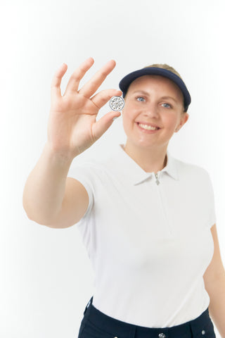 Navy Clip ladies golf visor,  100% polyester with quick-drying fabrics. The visor comes in a one size fits all design which clips around your head to hold it securely in place. It features a concealed magnet in in the strong curved, crystal detailed peak with a hand enameled flower look golf ball marker attached.  The headband features a soft lined absorbent towel.