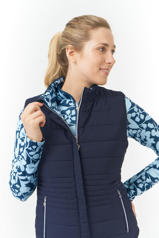 Pure Golf Eve reversible ladies gilet for golf is insulated, winter-weight, patterned and reversible. It has been Insulated for warmth without being bulky. One side features intricate Midnight Rose floral prints in navy and powder blue, while the other offers a classic plain navy option for versatility of wear. It has pockets on both sides and two-way zippers. The flattering quilting style and fit enhances your silhouette. 