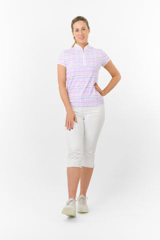 The Pure Golf model shot Rise Pastel Score cap sleeve ladies' golf polo shirt  features soft and refreshing pastel shades which give you a springtime vibe. With a regular fit and 4-way stretch, it ensures comfort and a flattering shape for all body types. The mandarin collar adds a touch of elegance. Crafted from 95% polyester and 5% spandex, it offers anti-crease, anti-static, and quick-dry properties, along with UPF 50+ sun protection. Paired with White Trust Capri's. 