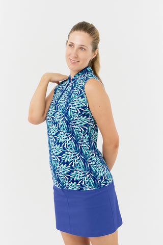 The Pure Golf Rise Sleeveless Women's Polo Shirt features a side view with prints that evoke a summery aquatic feel in multiple shades of blue. It is paired with the Yale Navy Skort. Designed with a regular fit, the polo provides 4-way stretch for comfort and a flattering silhouette on all body types. The elegant Mandarin collar adds a fashionable element. Crafted from 95% Polyester and 5% Spandex, it offers anti-crease, anti-static, and quick-dry benefits, along with UPF 50+ sun protection.