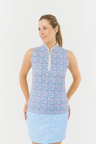 The model showcases the Pure Golf Rise Over Eighteen Sleeveless Ladies' Golf Polo Shirt, featuring the "Over Eighteen" print adorned with subtle cocktail motifs in soft shades of blue, lilac, and pink. It is designed with a mid zip and white trim, offering a regular fit and 4-way stretch for comfort on all body types. The mandarin collar adds a stylish touch. Made from a blend of 95% polyester and 5% spandex, this polo shirt boasts anti-crease, anti-static, and quick-dry properties, along with UPF 50+