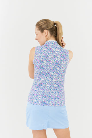 The model shot from the back highlights the Pure Golf Rise Over Eighteen Sleeveless Ladies' Golf Polo Shirt, featuring the “Over Eighteen” print with subtle cocktail motifs in a soft blend of blues, lilacs, and pinks. It includes a mid zip with white trim, offering a regular fit and 4-way stretch for comfort across all body types. The mandarin collar adds an elegant touch. Made from 95% polyester and 5% spandex, designed with anti-crease, anti-static, and quick-dry properties, plus UPF 50+ sun protection.