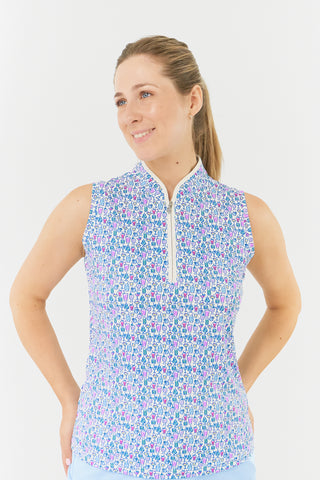 The close up model shot highlights the Pure Golf Rise Over Eighteen Sleeveless Ladies' Golf Polo Shirt, featuring the “Over Eighteen” print with subtle cocktail motifs in a soft blend of blues, lilacs, and pinks. It includes a mid zip with white trim, offering a regular fit and 4-way stretch for comfort across all body types. The mandarin collar adds an elegant touch. Made from 95% polyester and 5% spandex, designed with anti-crease, anti-static, and quick-dry properties, plus UPF 50+ sun protection.