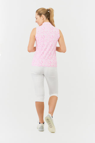 The Pure Golf rise sleeveless ladies' golf polo shirt in Soft Sakura model back shot showcases a subtle print of lilac, pink and white petals on a light pink backdrop. Designed with a regular fit, it offers a 4-way stretch for comfort and a flattering shape on all body types. The mandarin collar offers adds a touch of elegance. Made from 95% Polyester and 5% Spandex, offering anti-crease, anti-static, and quick-dry properties, along with UPF 50+ sun protection. Paired with White Trust Capri's. 