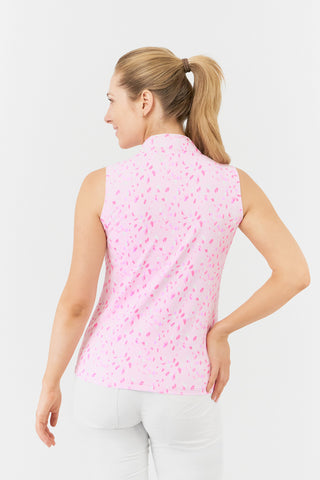 The Pure Golf rise sleeveless ladies' golf polo shirt in Soft Sakura model close-up back shot showcases a subtle print of lilac, pink and white petals on a light pink backdrop. Designed with a regular fit, it offers a 4-way stretch for comfort and a flattering shape on all body types. The mandarin collar offers adds a touch of elegance. Made from 95% Polyester and 5% Spandex, offering anti-crease, anti-static, and quick-dry properties, along with UPF 50+ sun protection. Paired with White Bermuda Shorts.