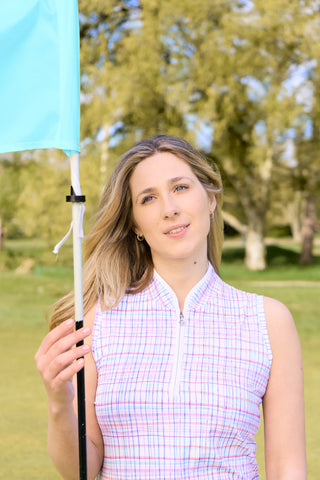 The close up Lifestyle shot shows the Pure Golf Rise Pastel Score sleeveless ladies' golf polo shirt  features soft and refreshing pastel shades which give you a springtime vibe. With a regular fit and 4-way stretch, it ensures comfort and a flattering shape for all body types. The mandarin collar adds a touch of elegance. Crafted from 95% polyester and 5% spandex, it offers anti-crease, anti-static, and quick-dry properties, along with UPF 50+ sun protection.