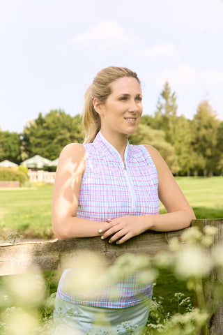 The lifestyle shot features the Pure Golf Rise Pastel Score Sleeveless Ladies' Golf Polo Shirt, showcasing soft, refreshing pastel shades that capture a springtime feel. With a regular fit and 4-way stretch, it ensures comfort and a flattering silhouette for all body types. The mandarin collar adds an elegant touch. Made from 95% polyester and 5% spandex, this polo offers anti-crease, anti-static, and quick-dry properties, along with UPF 50+ sun protection.