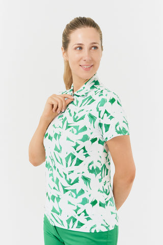 The Pure Golf Amity model half shot of the short sleeve ladies golf polo shirt with botanical print in emerald green and white. The polo shirt is a regular fit and has a 4 way stretch which ensures it is comfortable and flattering for all body types. It boasts a traditional collar for a classic and stylish look. The polo shirt is anti-crease, anti-static and quick dry with UPF 50+ which is 95% Polyester and 5% Spandex. 