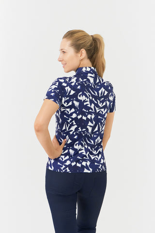 The Pure Golf Amity model shot features the back of the short-sleeve ladies' golf polo shirt, adorned with a botanical print in navy and white. This regular-fit polo shirt provides a 4-way stretch for comfort and a flattering fit on all body types. Its traditional collar adds a classic and stylish touch. Designed to be anti-crease, anti-static, and quick-drying, the shirt also offers UPF 50+ protection. Made from 95% polyester and 5% spandex. 