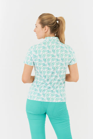 The product shot displays the back view of the Pure Golf Amity Short Sleeve Ladies' Golf Polo Shirt in Floating Palms White, featuring a striking botanical print in Ocean on a crisp white background. This regular-fit polo offers a 4-way stretch for comfort and a flattering fit for all body types. The traditional collar adds a classic touch. Designed to be anti-crease, anti-static, and quick-drying, the shirt also provides UPF 50+ sun protection, crafted from 95% Polyester and 5% Spandex.