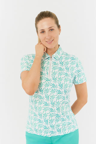 The close-up model shot of the Pure Golf Amity Short Sleeve Ladies' Golf Polo Shirt in Floating Palms White features a striking botanical print in Ocean on a crisp white background. This regular-fit polo provides a 4-way stretch for comfort and a flattering fit for all body types. The traditional collar adds a classic touch. Designed to be anti-crease, anti-static, and quick-drying, the shirt also offers UPF 50+ sun protection, crafted from 95% Polyester and 5% Spandex.