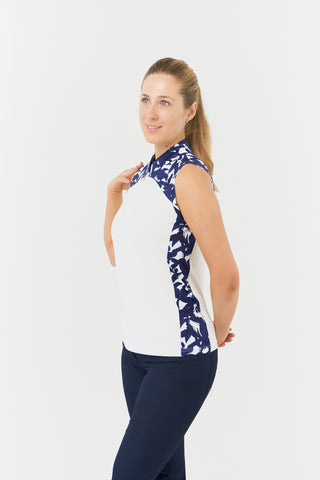 The Pure Golf Freda model shot highlights the sleeveless ladies' golf polo shirt, featuring a botanical print in navy and white across the shoulders, sides, and mandarin collar, complemented by a white body. This regular-fit polo shirt offers a 4-way stretch for comfort and a flattering fit on all body types. Designed to be anti-crease, anti-static, and quick-drying, it also provides UPF 50+ protection. Made from 95% Polyester and 5% Spandex. 