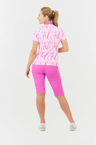 The Pure Golf Felicity short-sleeve ladies' polo shirt, captured from the back, highlights the delicate layers of pink and white feathers. Showcased with Azalea Pink Bermuda Shorts. Designed for a regular fit, it features a 4-way stretch for comfort and a flattering silhouette on all body types. The chic sweetheart collar enhances its fashionable appeal. Crafted from 95% Polyester and 5% Spandex, this polo is anti-crease, anti-static, and quick-drying, while also providing UPF 50+ sun protection