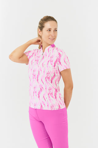 The Pure Golf Felicity short-sleeve ladies' polo shirt slight side model shot showcasing delicate layers of pink and white feathers. Designed with a regular fit, it offers a 4-way stretch for comfort and a flattering shape on all body types. The stylish sweetheart collar adds a fashionable touch. This polo is made from 95% Polyester and 5% Spandex, offering anti-crease, anti-static, and quick-dry properties, along with UPF 50+ sun protection