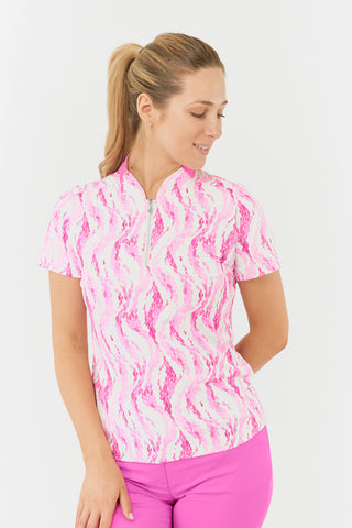 The Pure Golf Felicity short-sleeve ladies' polo shirt features a front view showcasing delicate layers of pink and white feathers, paired with a matching pink skort. Designed with a regular fit, it offers a 4-way stretch for comfort and a flattering shape on all body types. The stylish sweetheart collar adds a fashionable touch. This polo is made from 95% Polyester and 5% Spandex, offering anti-crease, anti-static, and quick-dry properties, along with UPF 50+ sun protection.