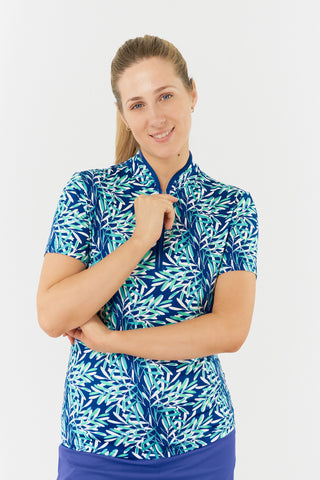 The Pure Golf Ellen short-sleeve ladies' polo shirt, featured in a model shot from the front top shot, showcases prints with a summery aquatic vibe in multi-blue tones. Designed with a regular fit, the polo offers a 4-way stretch for comfort and a flattering shape on all body types. The chic sweetheart collar adds a fashionable touch. Made from 95% Polyester and 5% Spandex, this polo is anti-crease, anti-static, and quick-drying, while providing UPF 50+ 