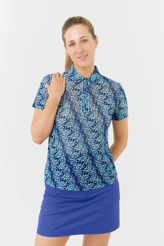 The model front shot of the Pure Golf Serendipity Mesh Short Sleeve Polo Shirt in Floating Palms-Yale, showcasing prints with a summery aquatic essence of multi-blue tones. The breathable mesh fabric, ensures optimal airflow, keeping you cool on the course. Offering a 4-way stretch for comfort and a flattering shape on all body types. The stylish traditional collar adds a classic look. This polo is made from 95% Polyester and 5% Spandex, offering anti-crease, anti-static, and quick-dry properties. 