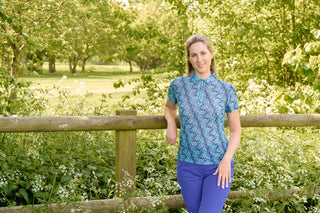 The Pure Golf Serendipity Mesh Short Sleeve Polo Shirt park lifestyle shot in the Floating Palms-Yale print highlights a refreshing summer vibe with its blend of multi-blue shades. Crafted from breathable mesh fabric, it promotes airflow to keep you cool on the course. With a 4-way stretch, it ensures comfort and a flattering fit for all body types. The classic collar adds a touch of sophistication. Made from 95% Polyester and 5% Spandex, this polo offers anti-crease, anti-static, and quick-dry benefits.