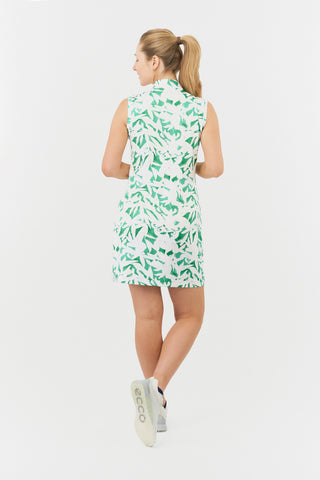 The Pure Golf from the back model shot of the Wild Peony Emerald Miley Sleeveless dress highlights our botanical print. Crafted from 4-way stretch fabric for improved flexibility and unrestricted movement, it ensures a flattering fit for all body types and includes detachable shorts for added versatility and coverage. The mock neck collar adds a sleek, modern touch. Designed to be anti-crease, anti-static, and quick-drying, this dress offers UPF 50+ protection. It is made from 95% Polyester and 5% Spandex.