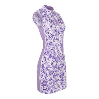 The Pure Golf side view product image showcasing the Heather Sleeveless Dress features a two-tone combination of purple and lilac, complemented by a slimming lilac side panel. Crafted from 4-way stretch fabric, it offers ultimate flexibility, while removable shorts provide extra coverage. The mock neck collar adds a modern, flattering touch for all body types. Designed to be anti-crease, anti-static, and quick-drying, this dress also provides UPF 50+ protection. It is made from 95% polyester and 5% spandex.