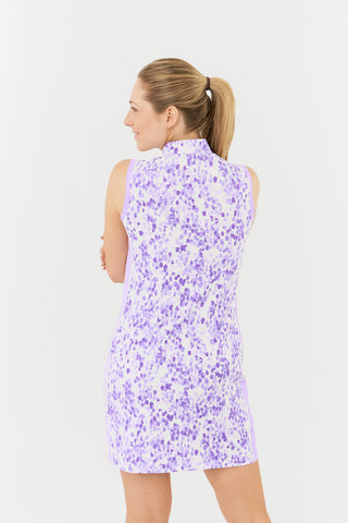 The Pure Golf product image showcasing the back view of the Heather Sleeveless Dress features a two-tone combination of purple and lilac, complemented by a slimming lilac side panel. Crafted from 4-way stretch fabric, offering flexibility, while removable shorts provide extra coverage. The mock neck collar adds a modern, flattering touch for all body types. Designed to be anti-crease, anti-static, and quick-drying, this dress also provides UPF 50+ protection. It is made from 95% polyester and 5% spandex.