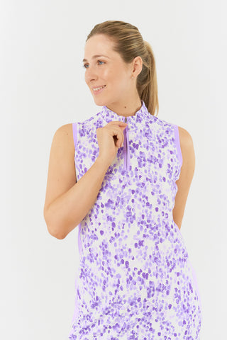 The Pure Golf model image showcasing the top of the Heather Sleeveless Dress features a two-tone combination of purple and lilac, complemented by a slimming lilac side panel. Crafted from 4-way stretch fabric, offering flexibility, while removable shorts provide extra coverage. The mock neck collar adds a modern, flattering touch for all body types. Designed to be anti-crease, anti-static, and quick-drying, this dress also provides UPF 50+ protection. It is made from 95% polyester and 5% spandex.