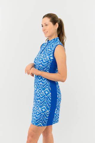 The Pure Golf model shot highlights the side of the Sophie Sleeveless dress, in our Santorini Skies print in shades of blue and white, complemented by a flattering Royal Blue side panel. Crafted from 4-way stretch fabric, it offers freedom of movement, with detachable shorts for added coverage. The mock neck collar adds a sleek touch, and the dress is designed to flatter all body types. Built to resist creasing, static, and moisture, providing UPF 50+ protection. Made from 95% Polyester and 5% Spandex. 