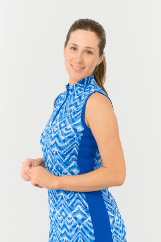 The Pure Golf model shot showcases the side of the Sophie Sleeveless dress, featuring our Santorini Skies print in shades of blue and white, with a flattering Royal Blue side panel. Crafted from 4-way stretch fabric, it provides freedom of movement and includes detachable shorts for added coverage. The mock neck collar adds a sleek touch, and the dress is designed to flatter all body types. Made to resist creasing, static, and moisture, it offers UPF 50+ protection. Made from 95% Polyester and 5% Spandex. 