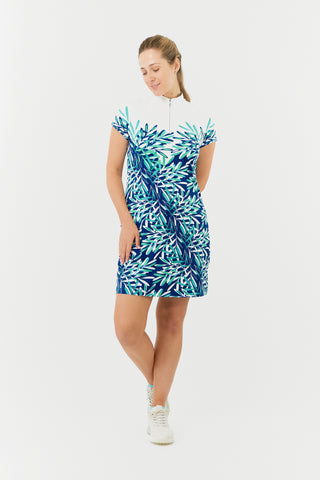 The Pure Golf model shot of the Carly Cap Sleeve dress features a summary aquatic of multi-blue and ocean tones with a print of floating palms from the chest downwards. Longer length dress made in 4-way stretch material for maximum flexibility with detachable shorts for coverage. Flattering fit on all body types. The mock neck collar offers a sleek, modern look. Designed to be anti-crease, anti-static, and quick drying, it also provides UPF 50+ protection. Made from 95% Polyester and 5% Spandex.