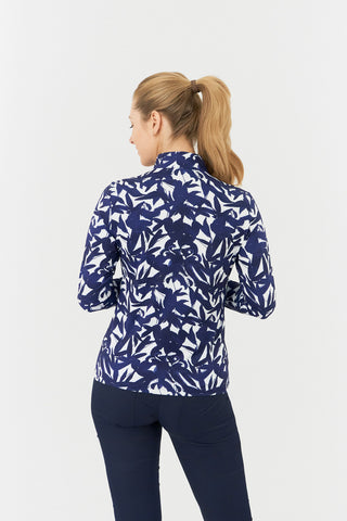 The Pure Golf Serenity long-sleeve ladies' golf zip top model shot showcasing a back view of our botanical print in Wild Peony Navy. Designed with a regular fit, it offers a 4-way stretch for comfort and a flattering shape on all body types. The mock neck collar offers a sleek, modern look and extra coverage. Made from 95% Polyester and 5% Spandex, offering anti-crease, anti-static, and quick-dry properties, along with UPF 50+ sun protection. 