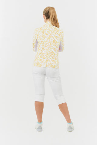 A model back shot of the Pure Golf Balance Sun Kissed Long Sleeve Ladies' Golf Zip Top from our Ray Flower collection features a beautiful print in warm honey hues. With a regular fit and 4-way stretch, it ensures comfort for all body types. The mock neck collar adds a sleek look, while white mesh sleeve panels enhance breathability. Crafted from 95% polyester and 5% spandex, it offers anti-crease, anti-static, and quick-dry properties, along with UPF 50+ protection. Paired with White Trust Capri's.