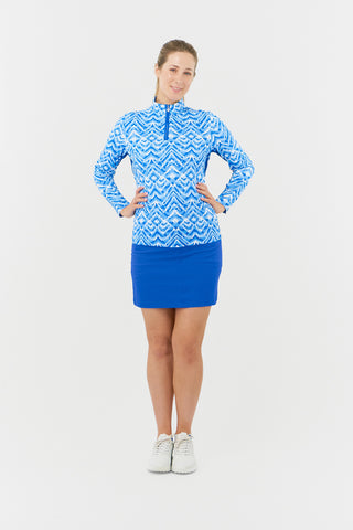 The Pure Golf Balance Santorini Skies long sleeve ladies' golf zip top features a mesmerizing Ikat-inspired design in blues and white. With a regular fit and 4-way stretch, it ensures comfort and a flattering shape for all body types. The mock neck collar offers a sleek look and the mesh inside sleeve and underarm panels in Royal Blue enhances breathability. Crafted from 95% polyester and 5% spandex, it offers anti-crease, anti-static, and quick-dry properties, along with UPF 50+ sun protection.