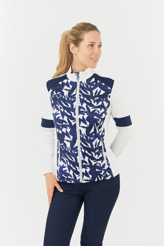 The Pure Golf Galena model shot highlights the front of the mid-layer jacket in Wild Peony, featuring a botanical navy and white print on the body and inner neck, white sleeves, a navy band around the elbow, and a navy block across the shoulders. Designed for comfort and a flattering fit, the jacket offers 4-way stretch to suit all body types. It is anti-crease, anti-static, quick-drying, and provides UPF 50+ sun protection. Made from 95% Polyester and 5% Spandex. 