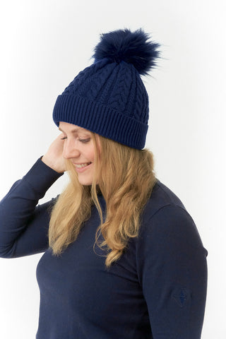 Navy ladies golf hat In an attractive cable knit design. This hat has three layers - an inner waterproof layer plus a soft fleece lining which makes it warm and comfortable. Detachable natural look faux fur bobble.