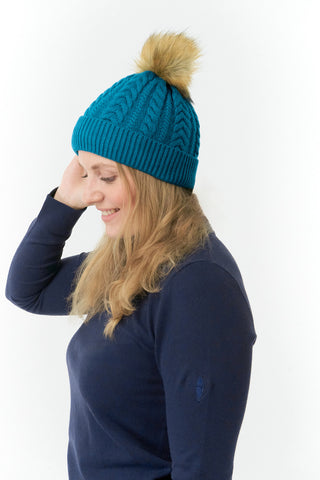 Teal ladies golf hat In an attractive cable knit design. This hat has three layers - an inner waterproof layer plus a soft fleece lining which makes it warm and comfortable. Detachable faux fur bobble in natural colours.