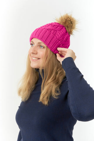 Pink ladies golf hat In an attractive cable knit design. This hat has three layers - an inner waterproof layer plus a soft fleece lining which makes it warm and comfortable. Detachable faux fur bobble in natural colours.